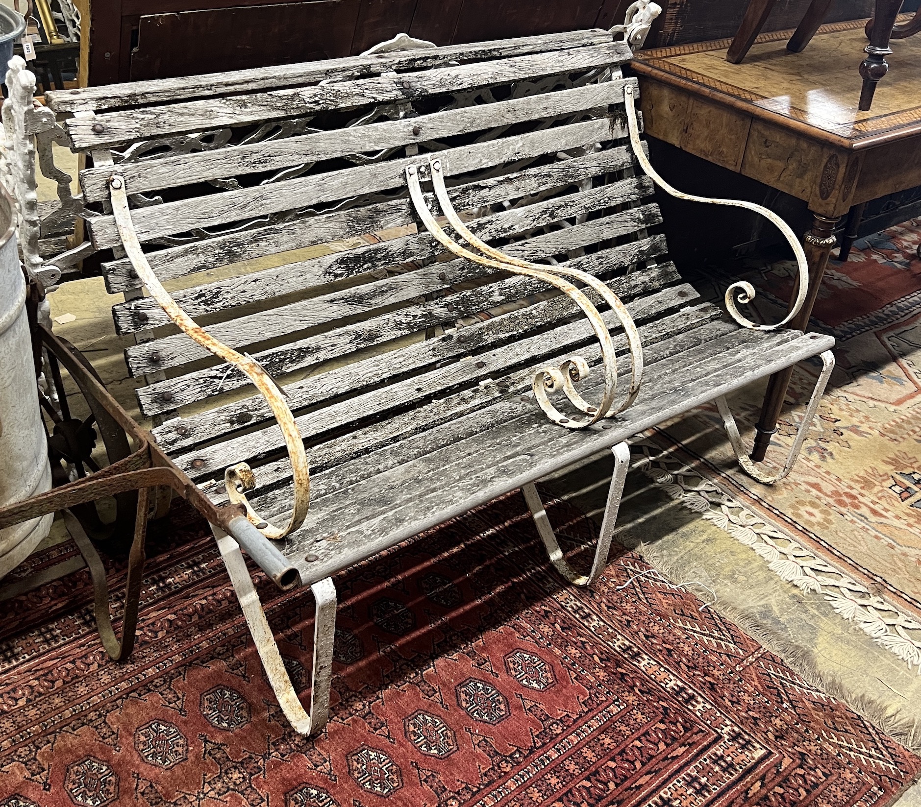 A vintage wrought iron and weathered teak two-seater garden bench, length 121cm, height 82cm